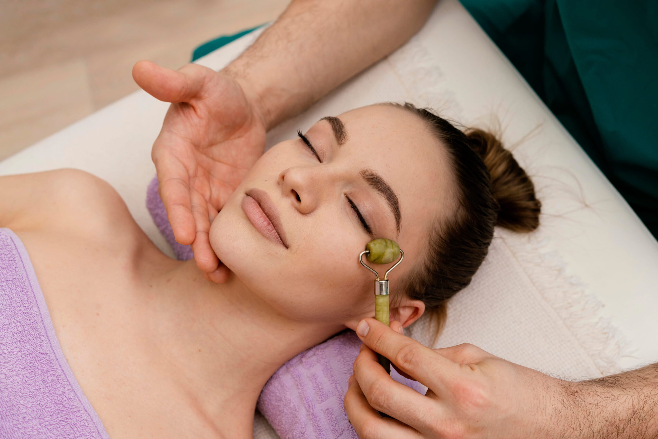 woman doing eye gua sha in a spa