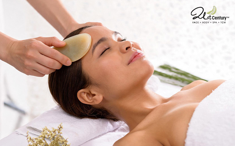 A close-up of a woman receiving a gentle gua sha facial treatment.